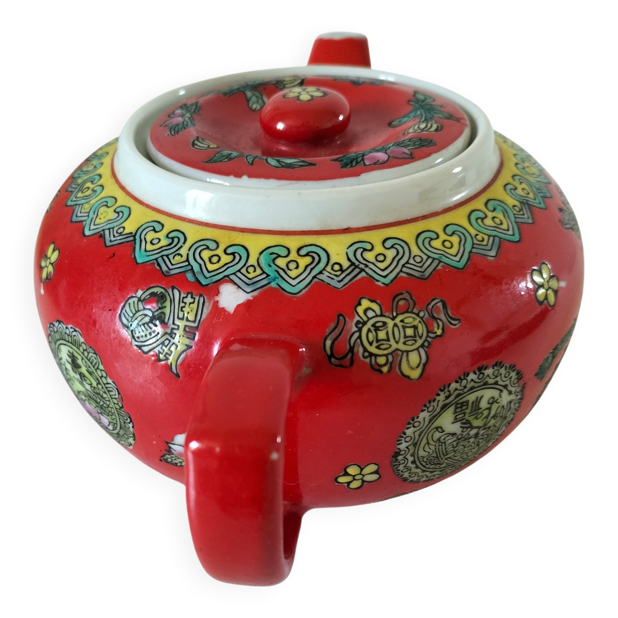 Vintage red Chinese teapot decorated with dragons and symbols.