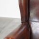 Fauteuil à oreilles confortable et bien entretenu en cuir de mouton