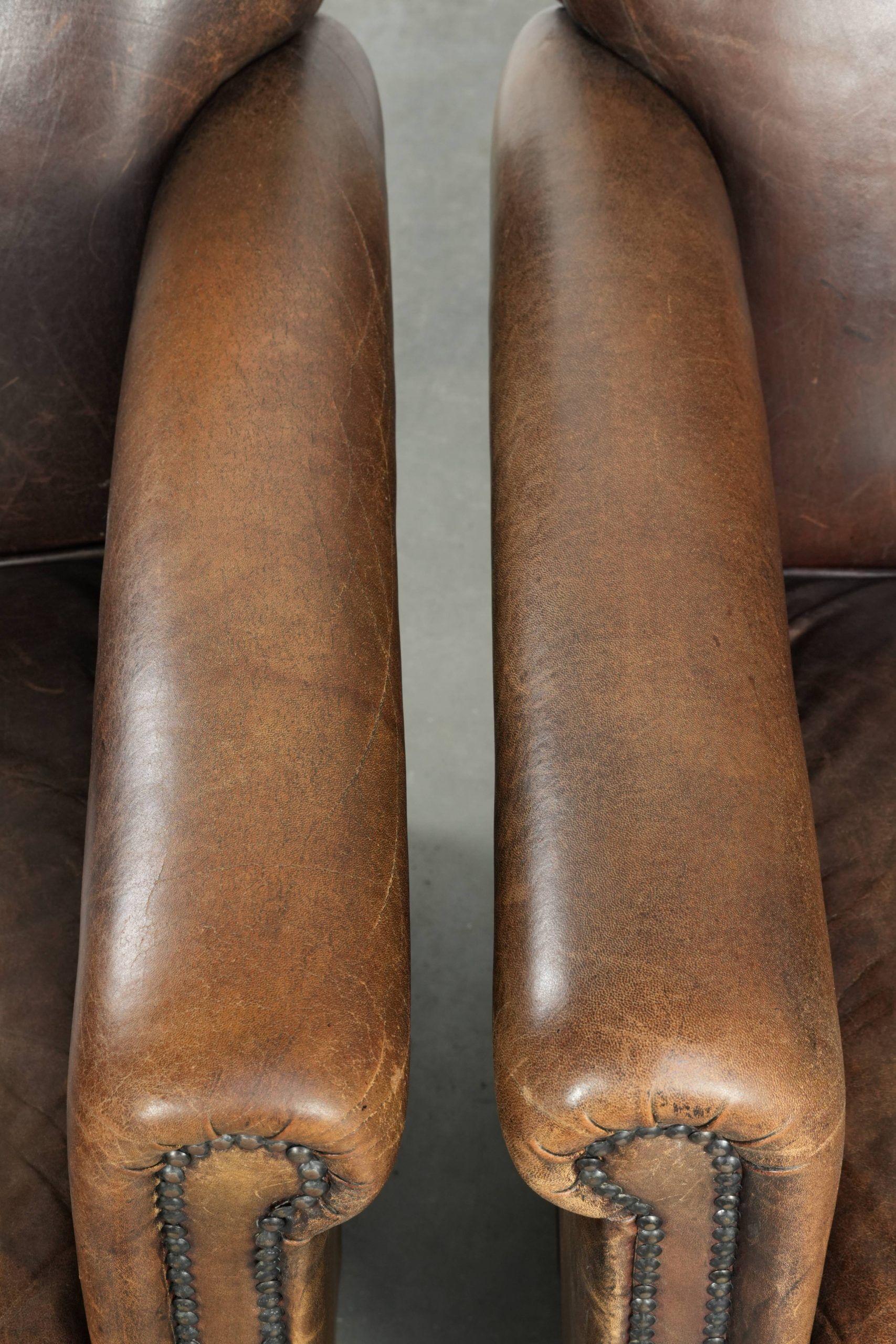 Characterful set of two sheepskin design armchairs with beautiful patina