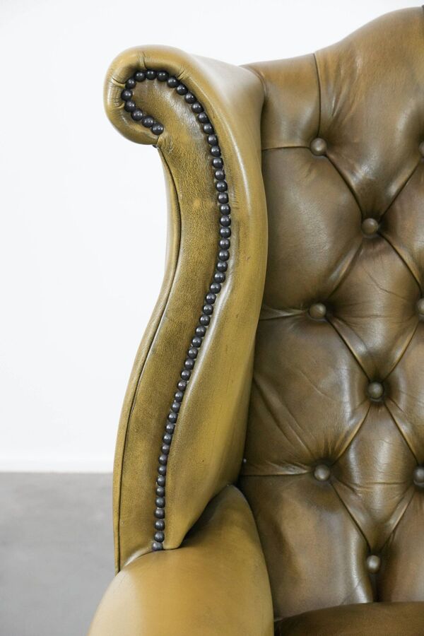Fauteuil à oreilles Chesterfield en cuir vachette vert mousse de style anglais.