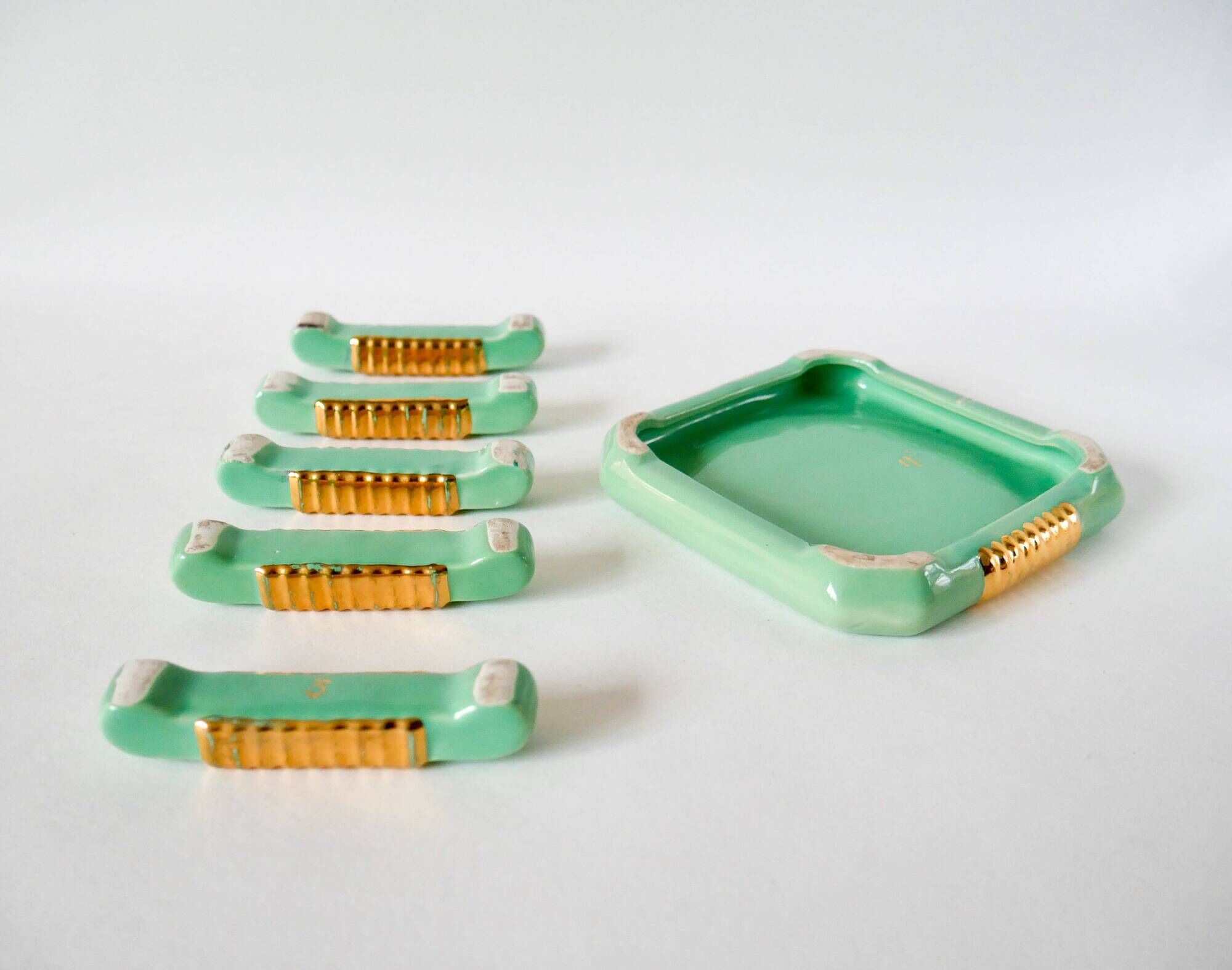 set of coasters and knife holders in mint green and gold art deco ceramic 1930