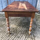 Antique farmhouse table in solid cherry wood with turned legs.