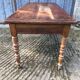 Antique farmhouse table in solid cherry wood with turned legs.