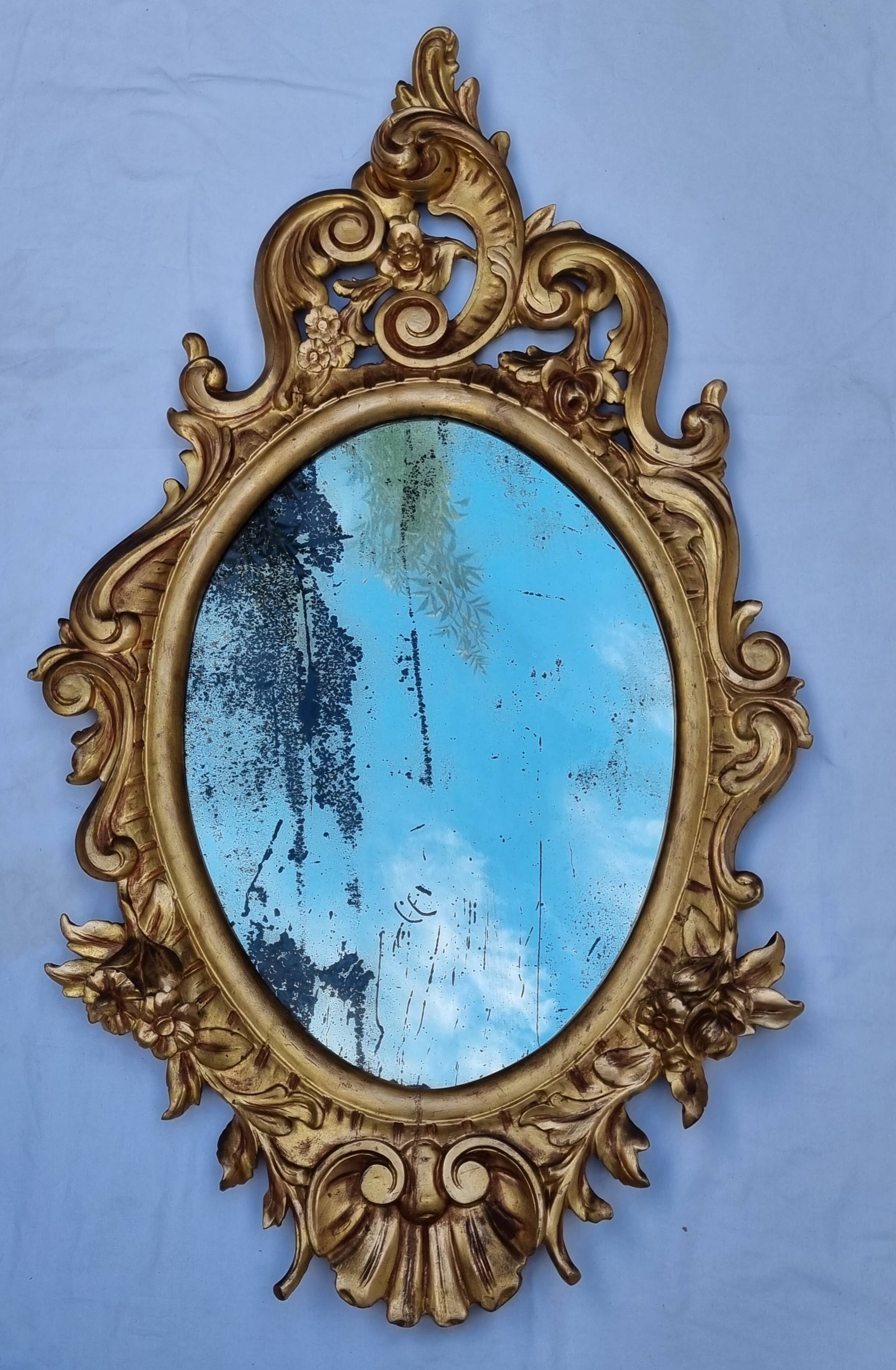 Large oval gold mirror, Louis XV rococo style, late 19th century, 114 x 66 cm.
