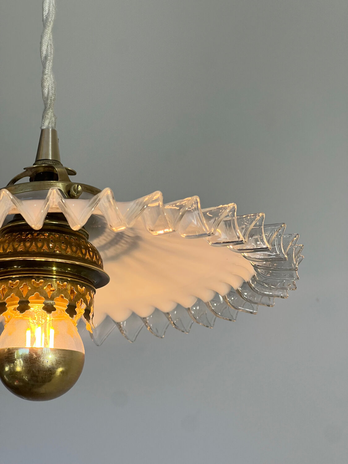 Opaline suspension in Art Deco style with a brass balcony featuring lace details.