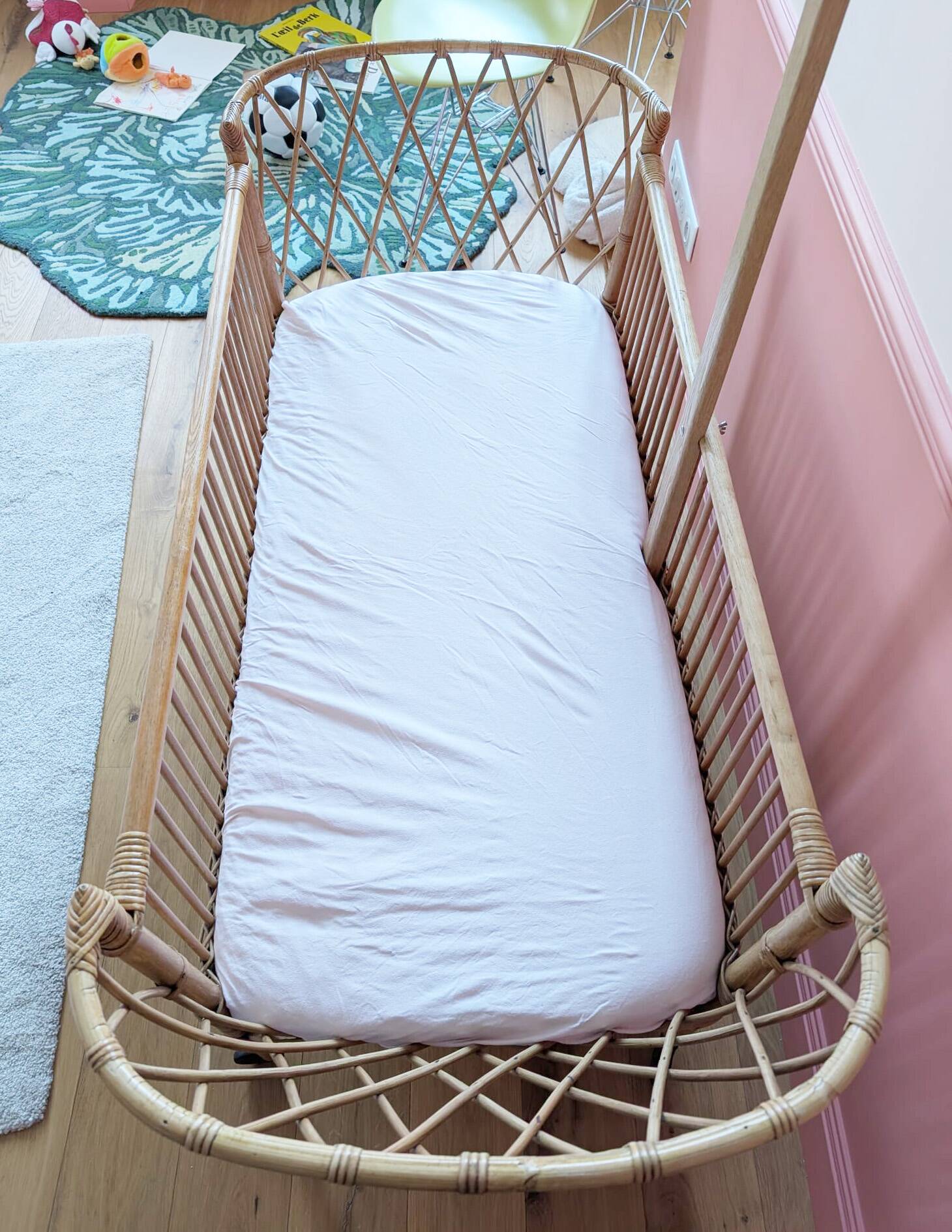 Newly refurbished rattan baby crib, with an oak arrow for a mobile.