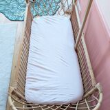 Newly refurbished rattan baby crib, with an oak arrow for a mobile.