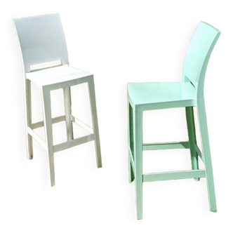 2 Kartell brand stools, one white and one pale green.