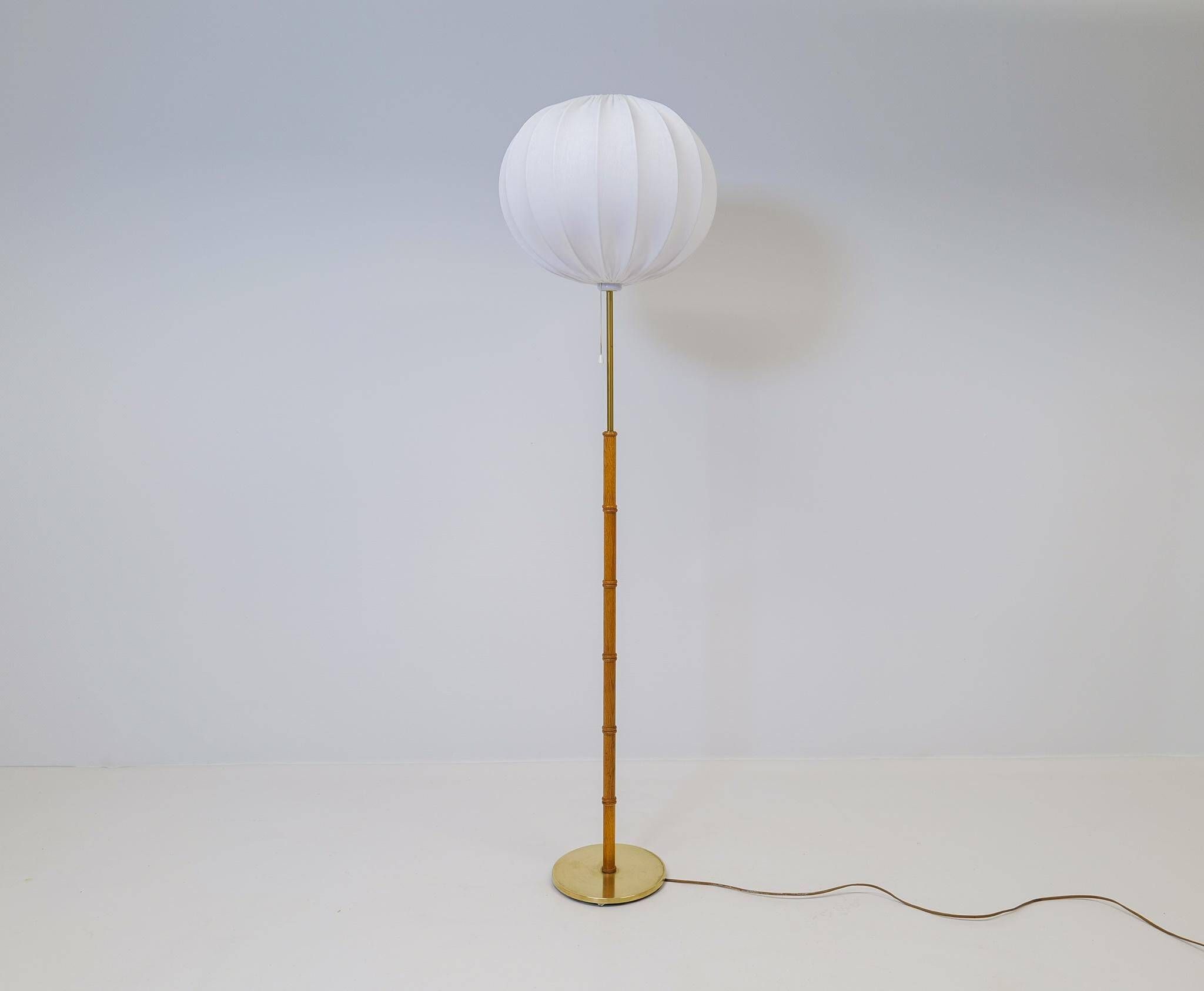 Mid-century floor lamp in brass and oak by Falkenbergs Belysning, Sweden, 1960s.