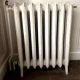 Radiateur ancien sur pieds à huit lames fleuries en fonte de fer XX siècle