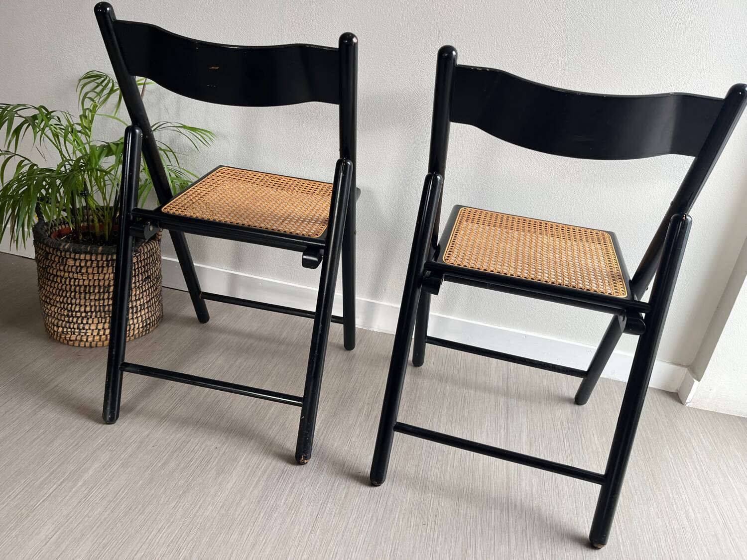Vintage folding chairs in black wood and cane.