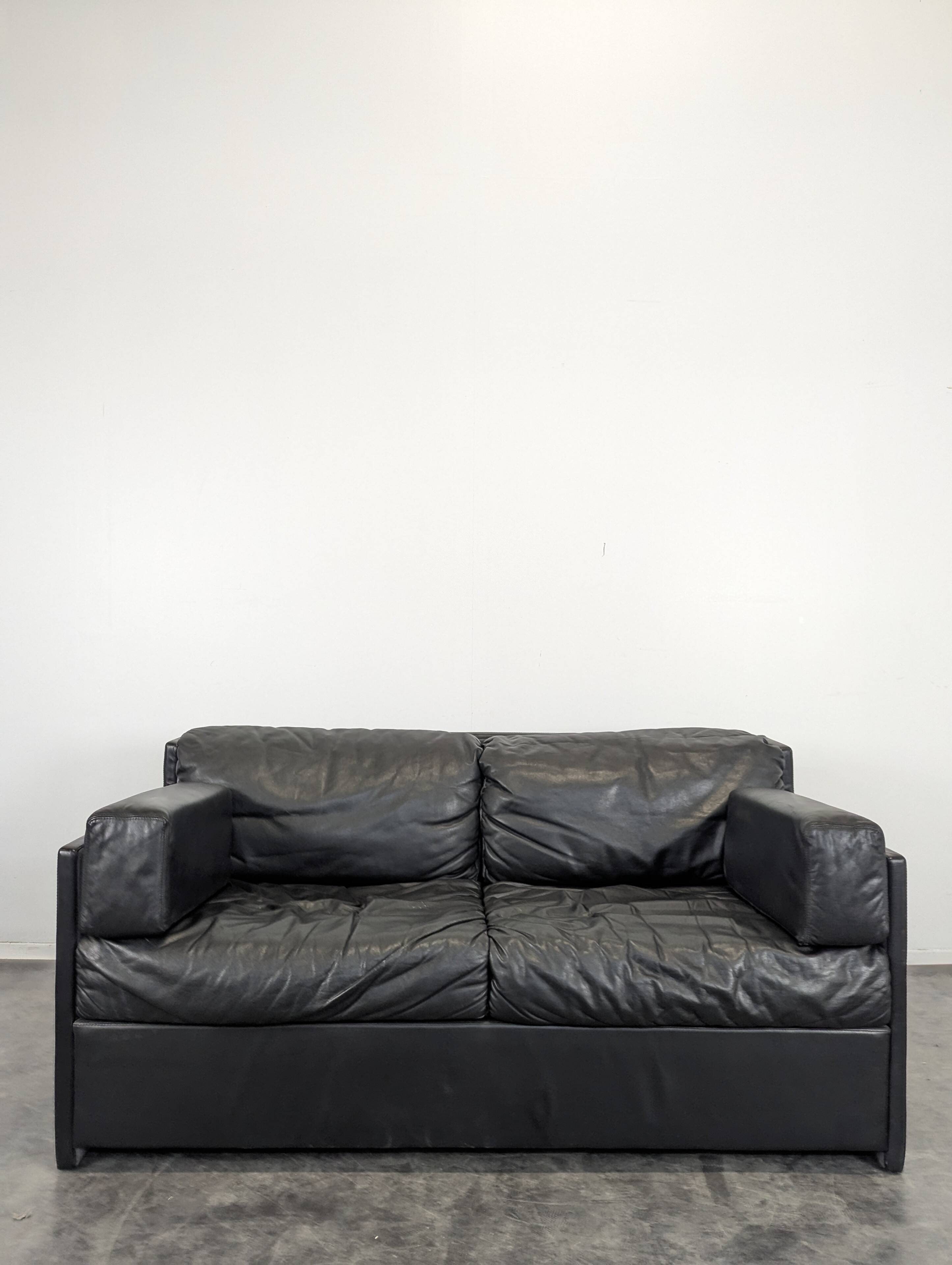 Black leather convertible sofa with goose feather upholstery.