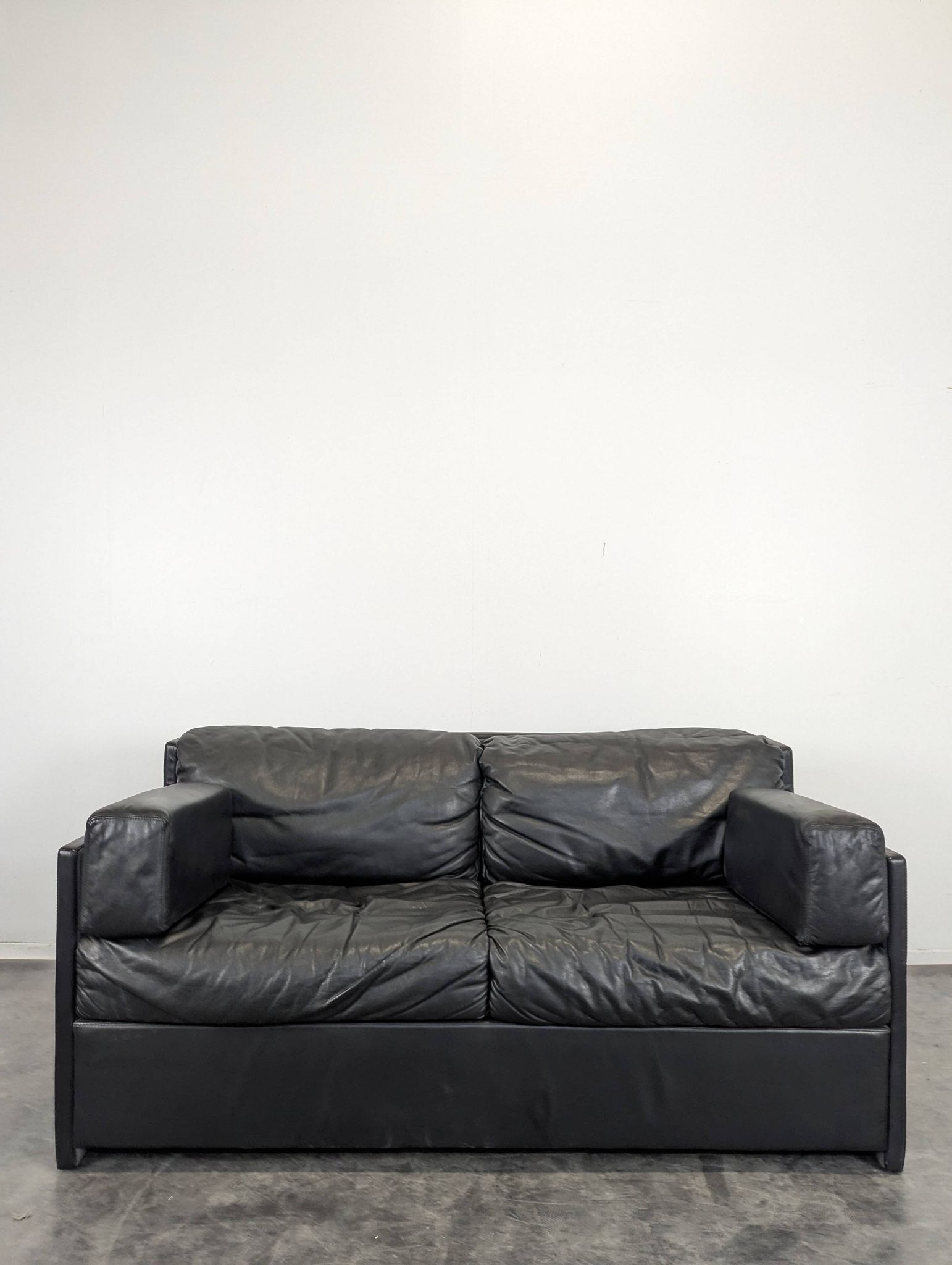 Black leather convertible sofa with goose feather upholstery.
