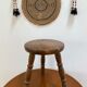 Old wooden tripod stool with ball feet