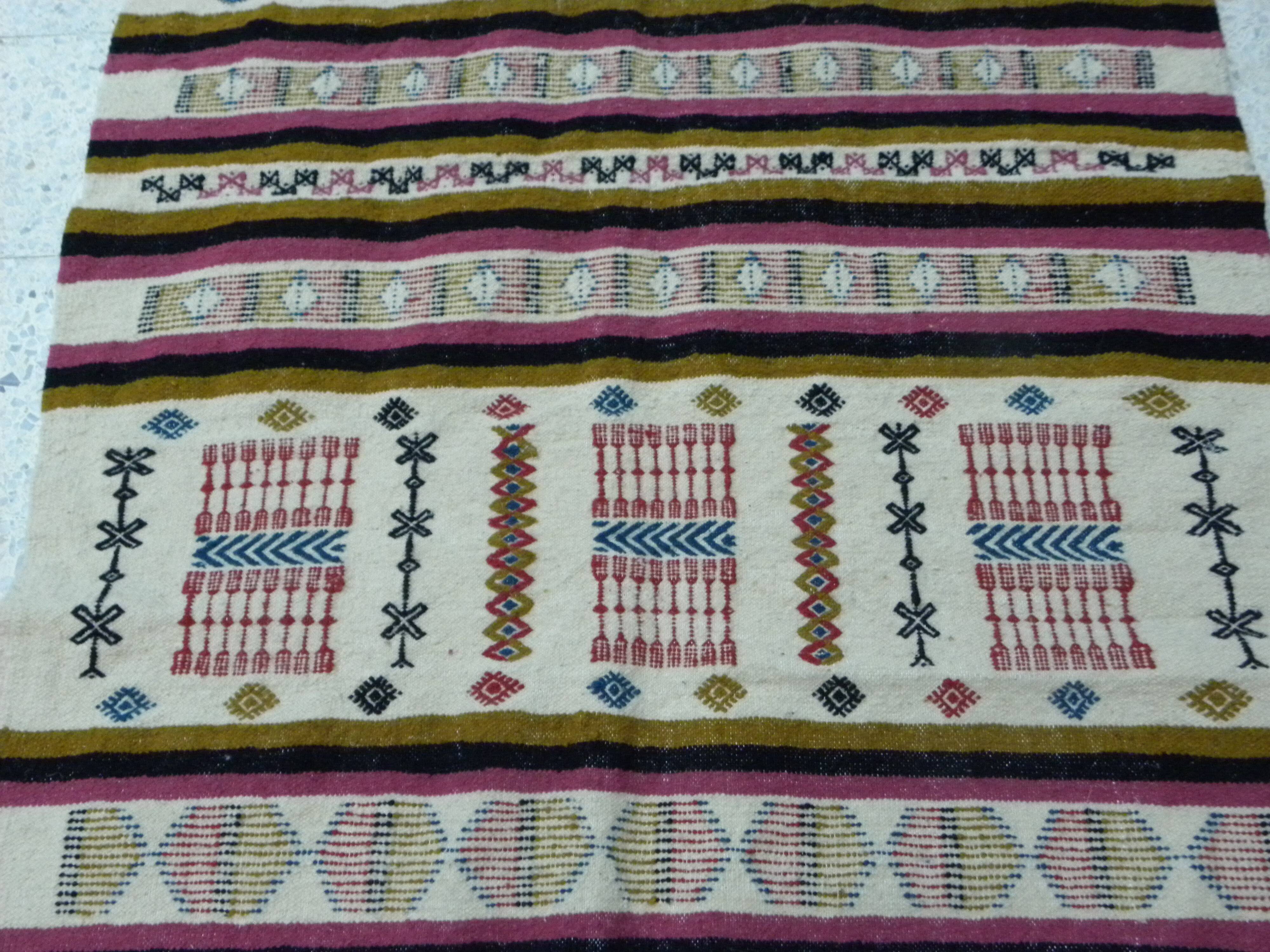 Handmade Berber kilim rug with multicoloured tribal motifs.