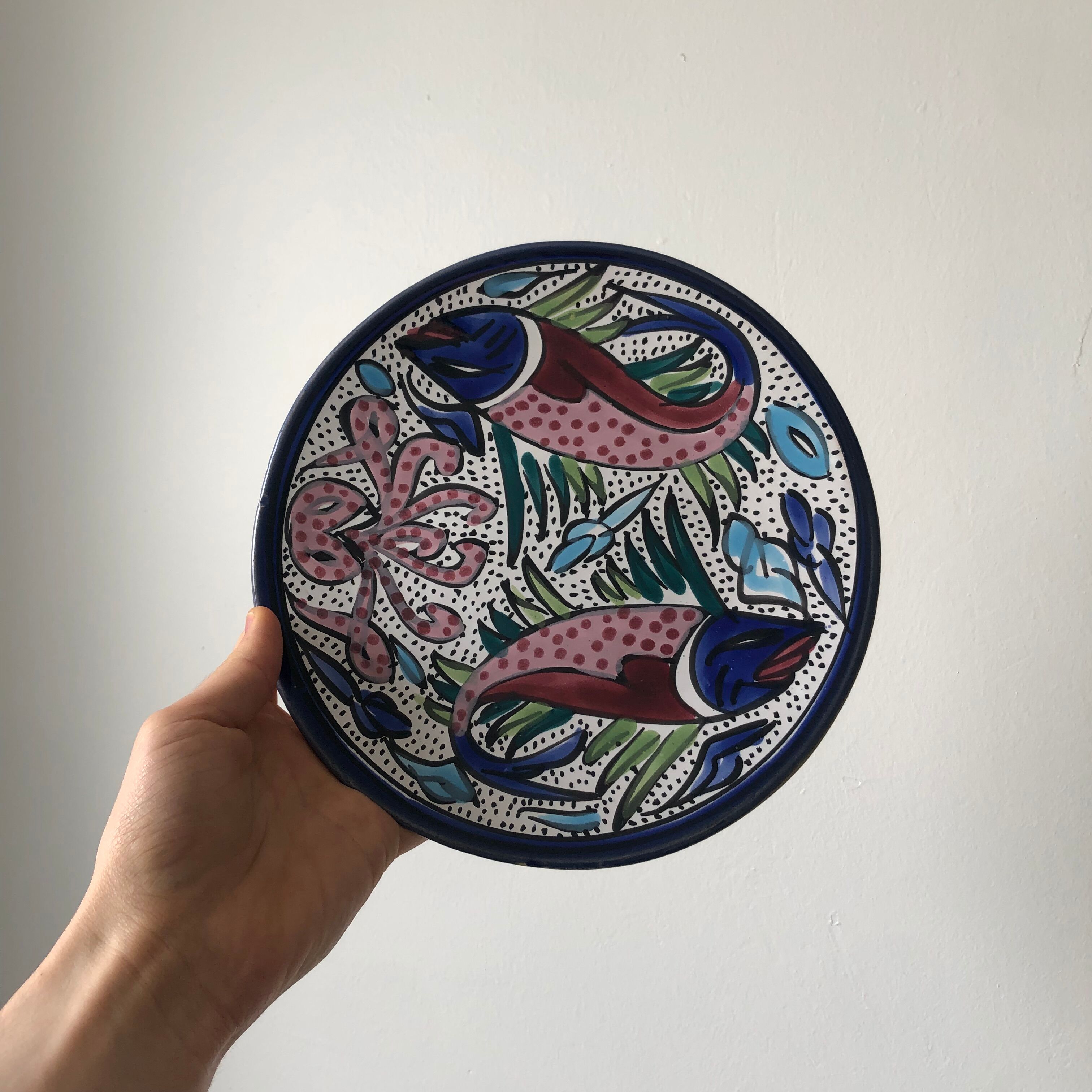 4 colorful flat plates with a fish pattern