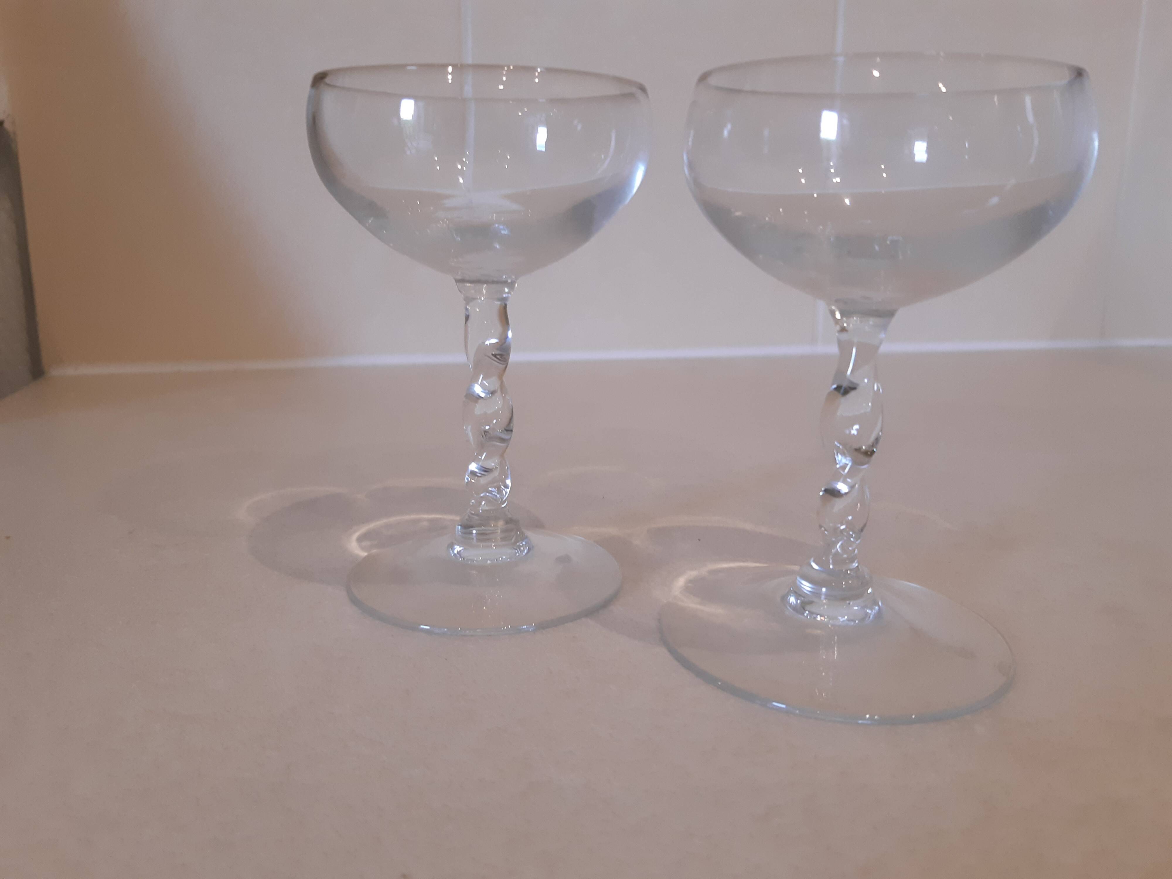 Two small crystal champagne glasses with twisted stems.