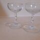 Two small crystal champagne glasses with twisted stems.