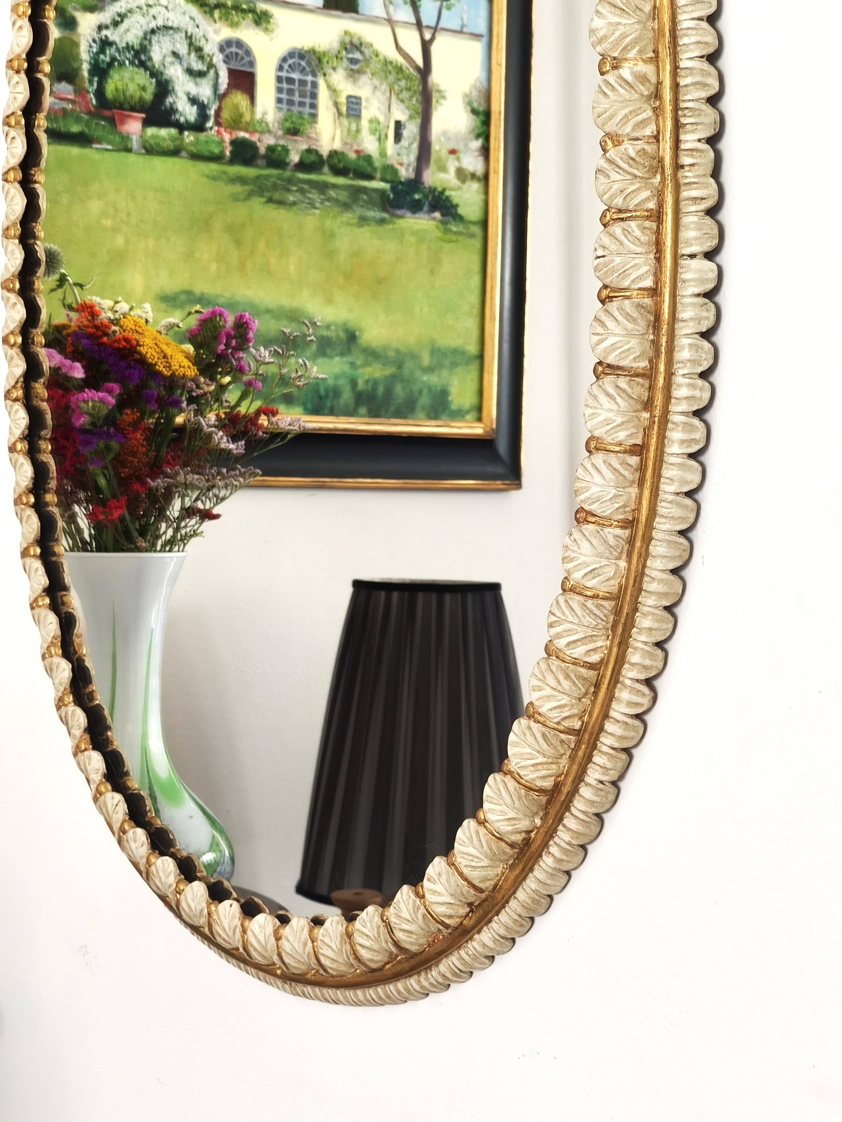 Large oval Florentine mirror in carved wood and gilded with gold leaf.