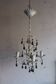 Antique white lacquered metal chandelier with wooden pendants.