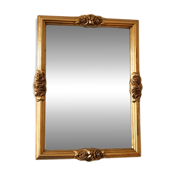 Miroir rectangulaire vintage en bois doré avec des accents de rose.