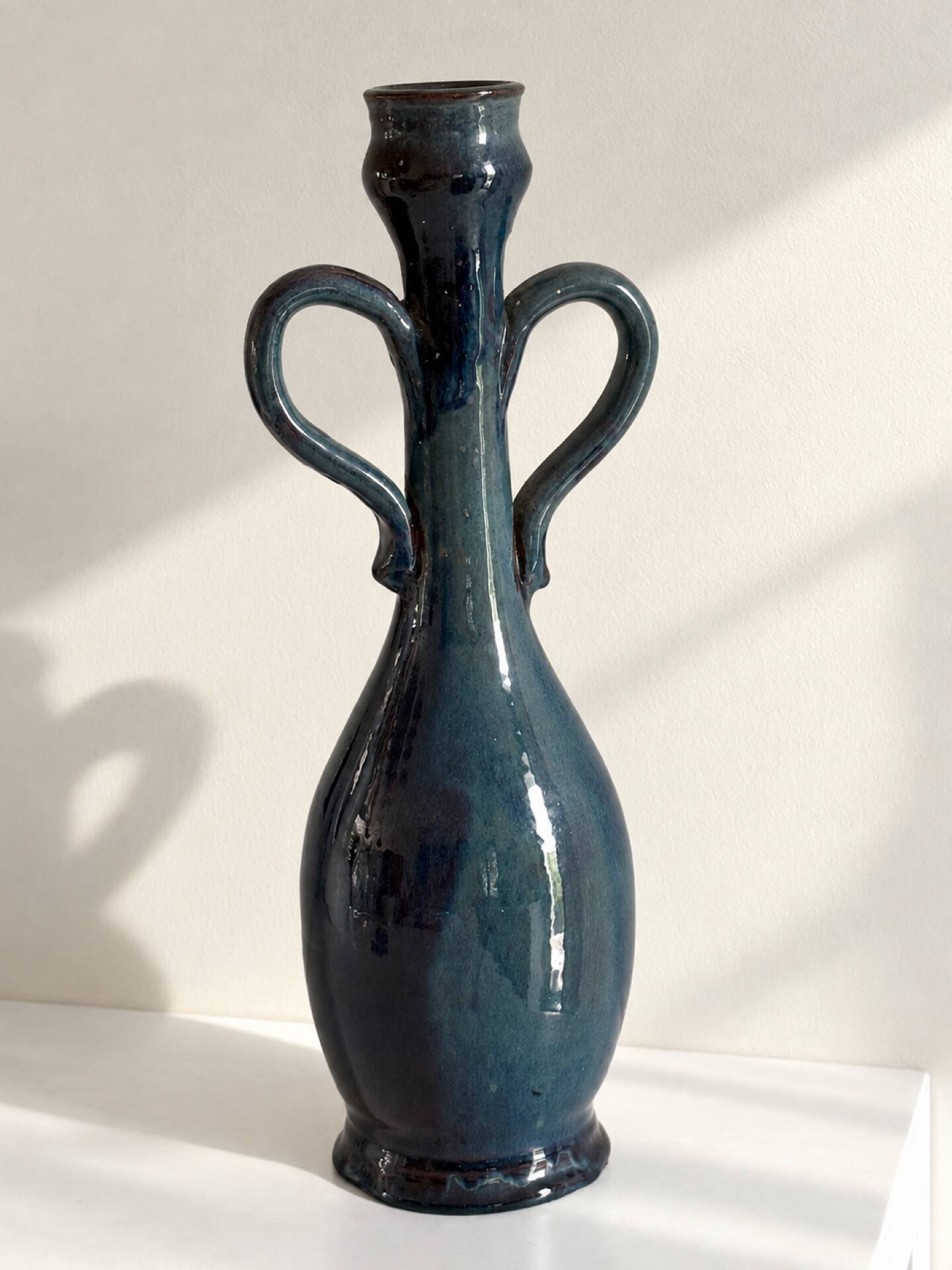 Decorative deep blue glazed ceramic vase with twin handles.