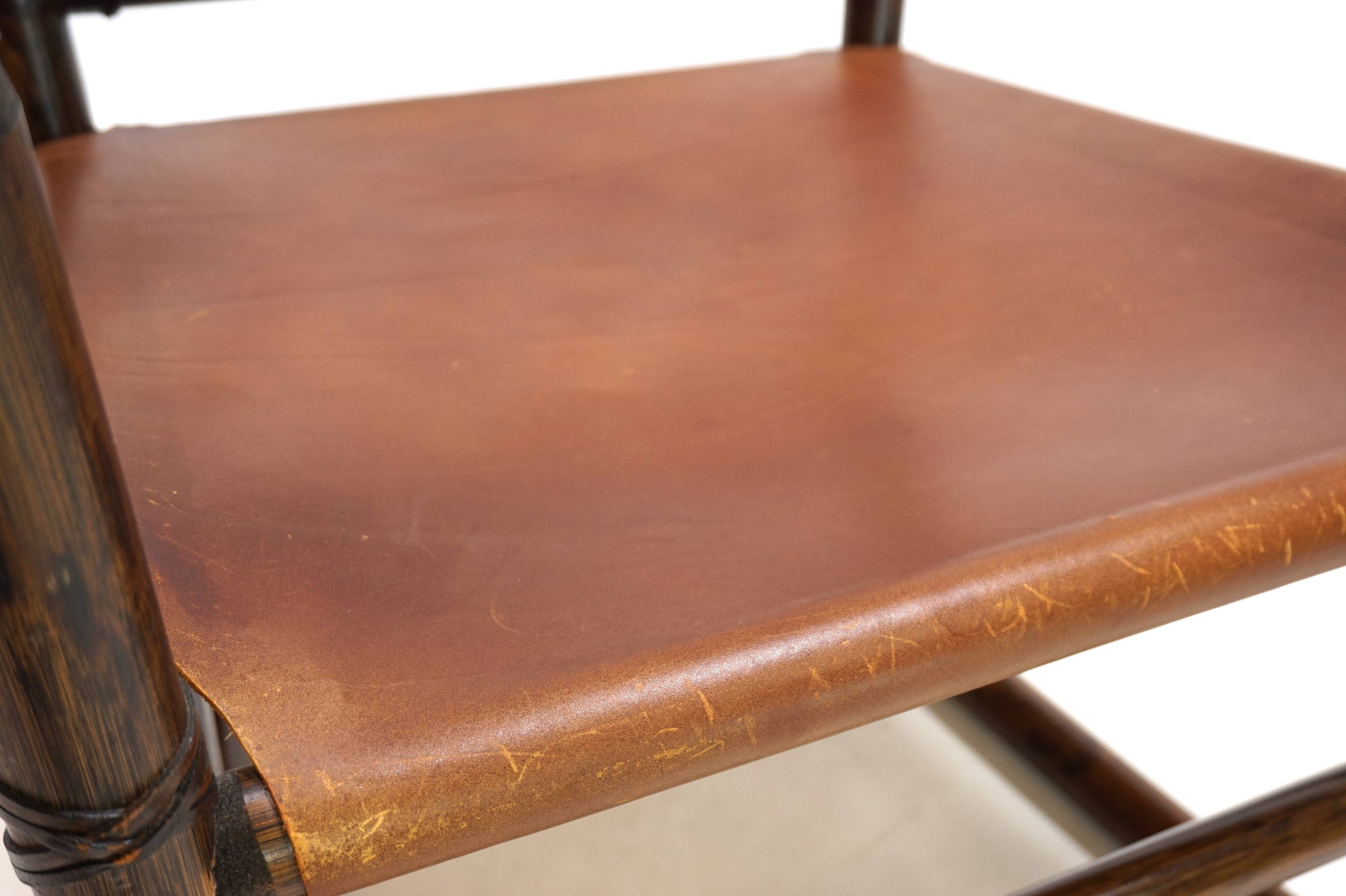 Fauteuil Manou en rotin et assise en cuir, 1960