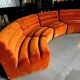 Burnt orange modular sofa for four with a futuristic design.