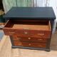 Vintage commode revamped in matte black & wood with warm tones.