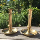 Paire de bougeoirs anciens en laiton à poussoir