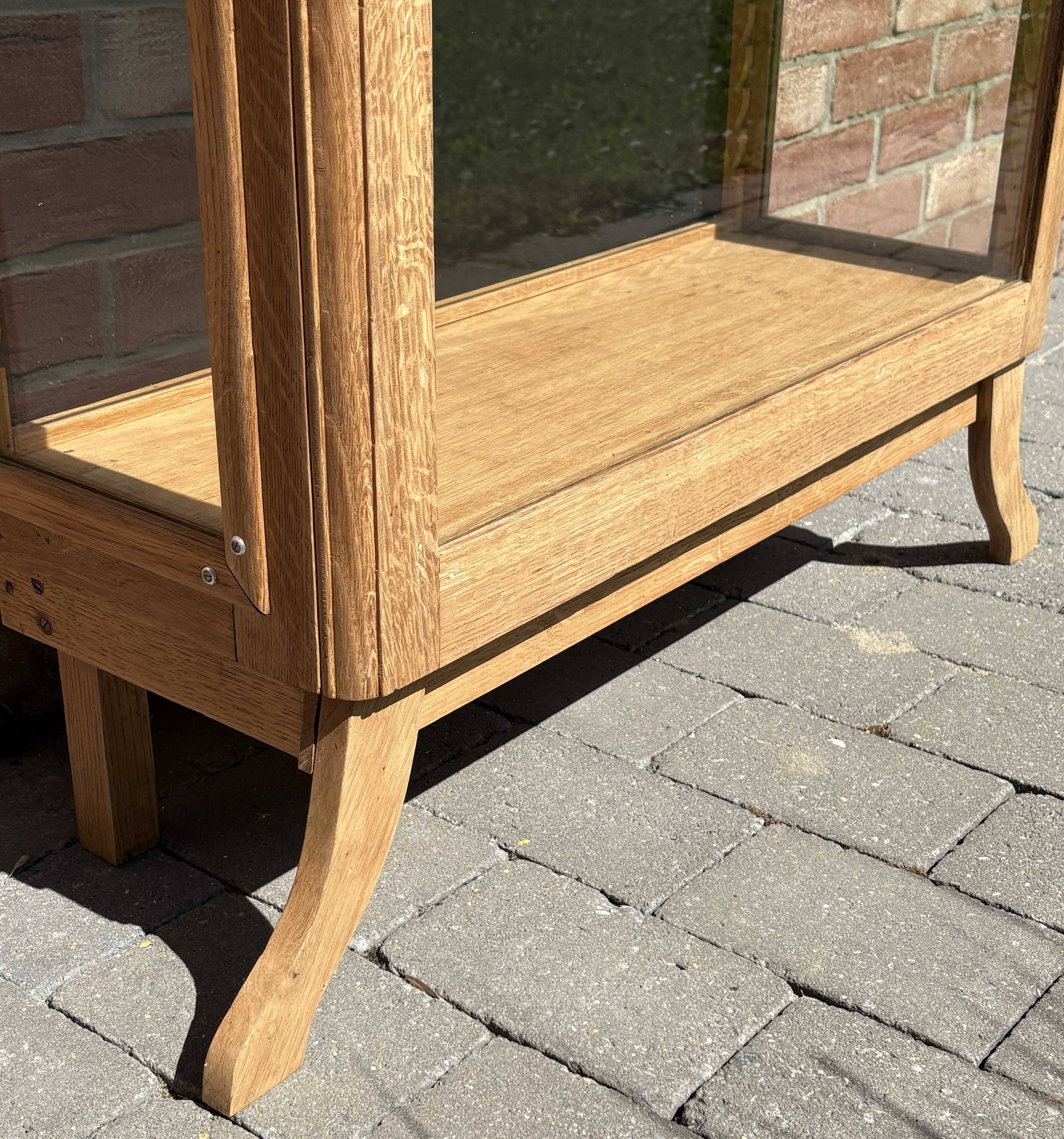 Restored antique oak display cabinet, black background, glass shelves.