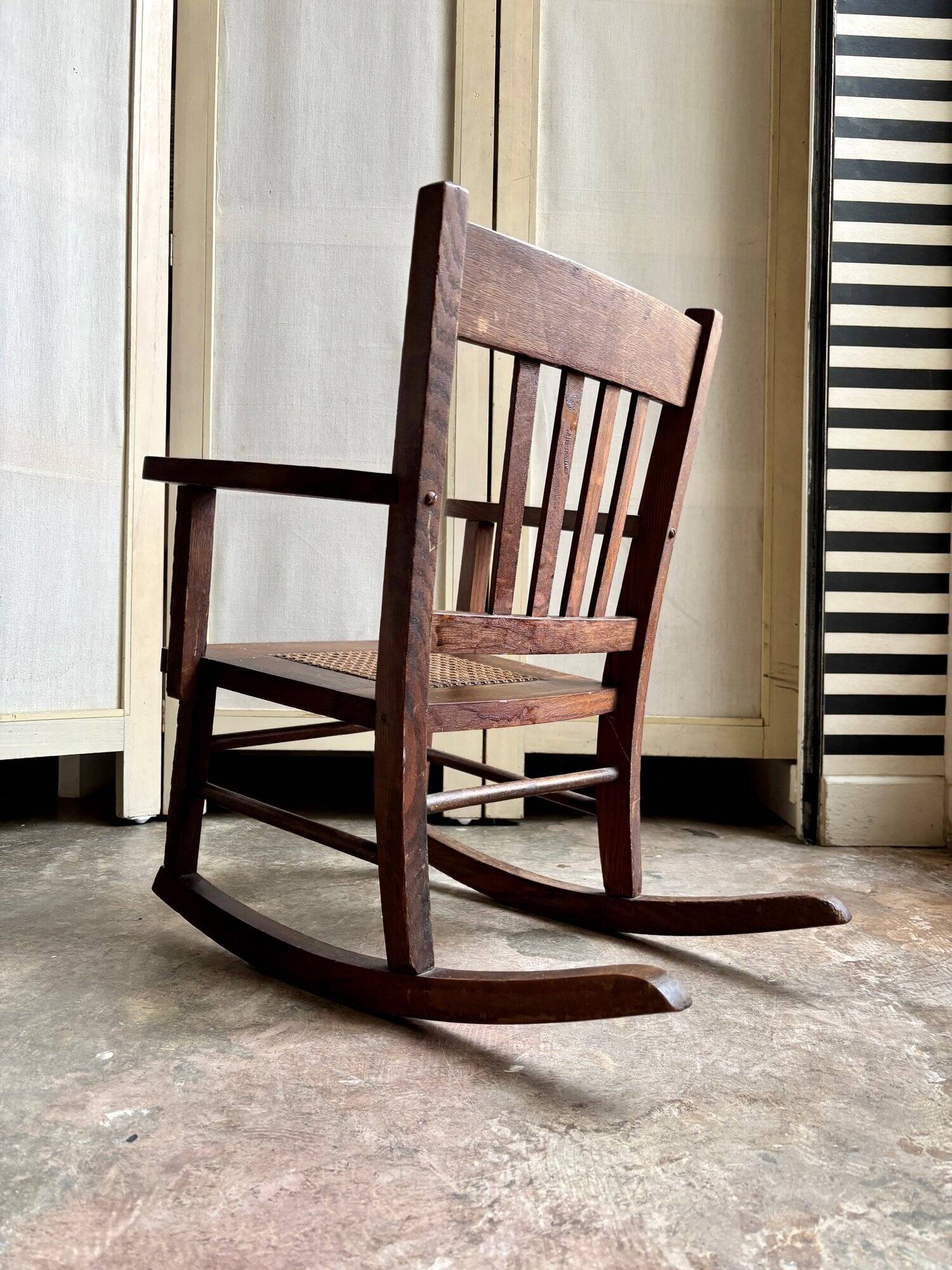 Children's rocking chair in dark wood and cane