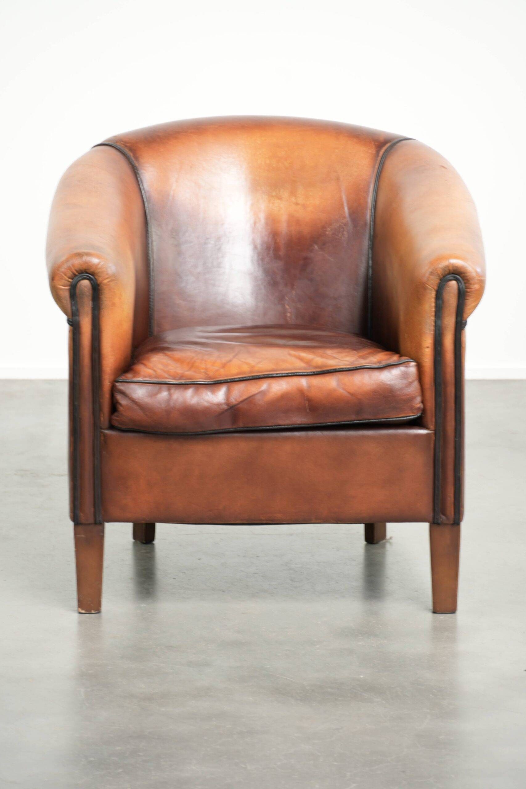 Vintage sheepskin club armchair finished with black piping