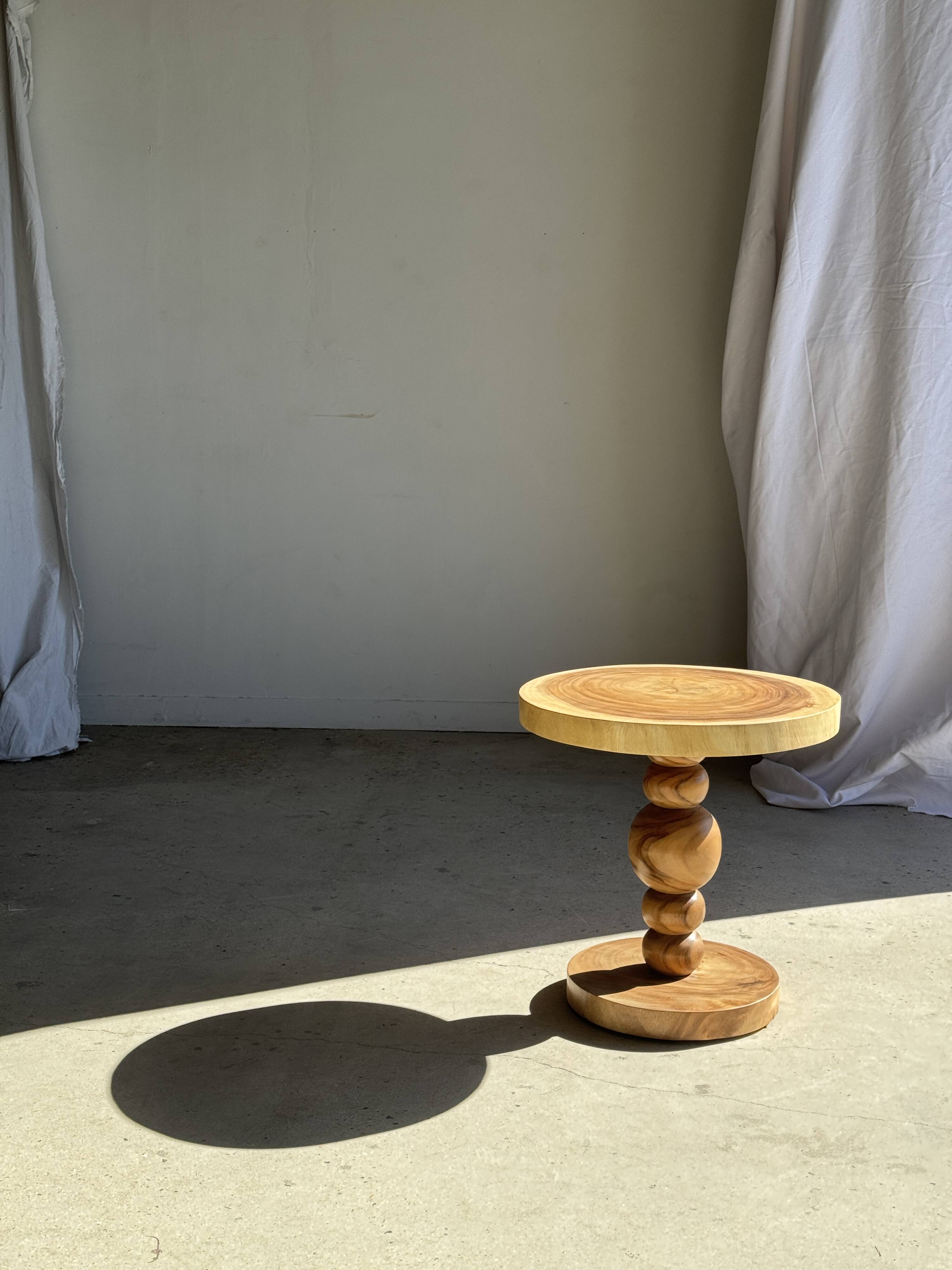 Coffee table in solid suar with central leg and spheres H56.5 D55.5