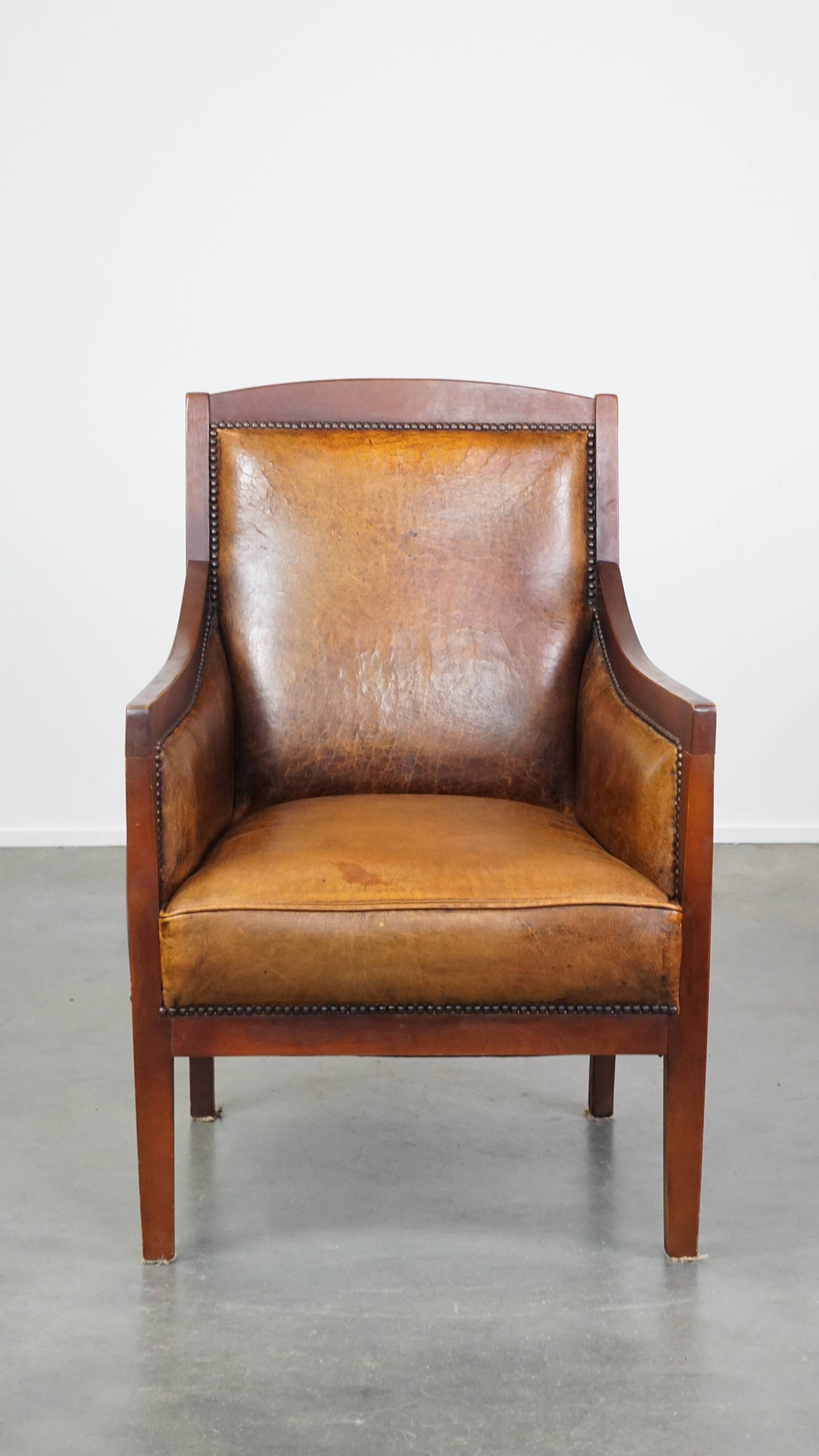 Sheepskin and wooden vintage Art Deco design armchair in a cognac color