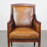 Sheepskin and wooden vintage Art Deco design armchair in a cognac color
