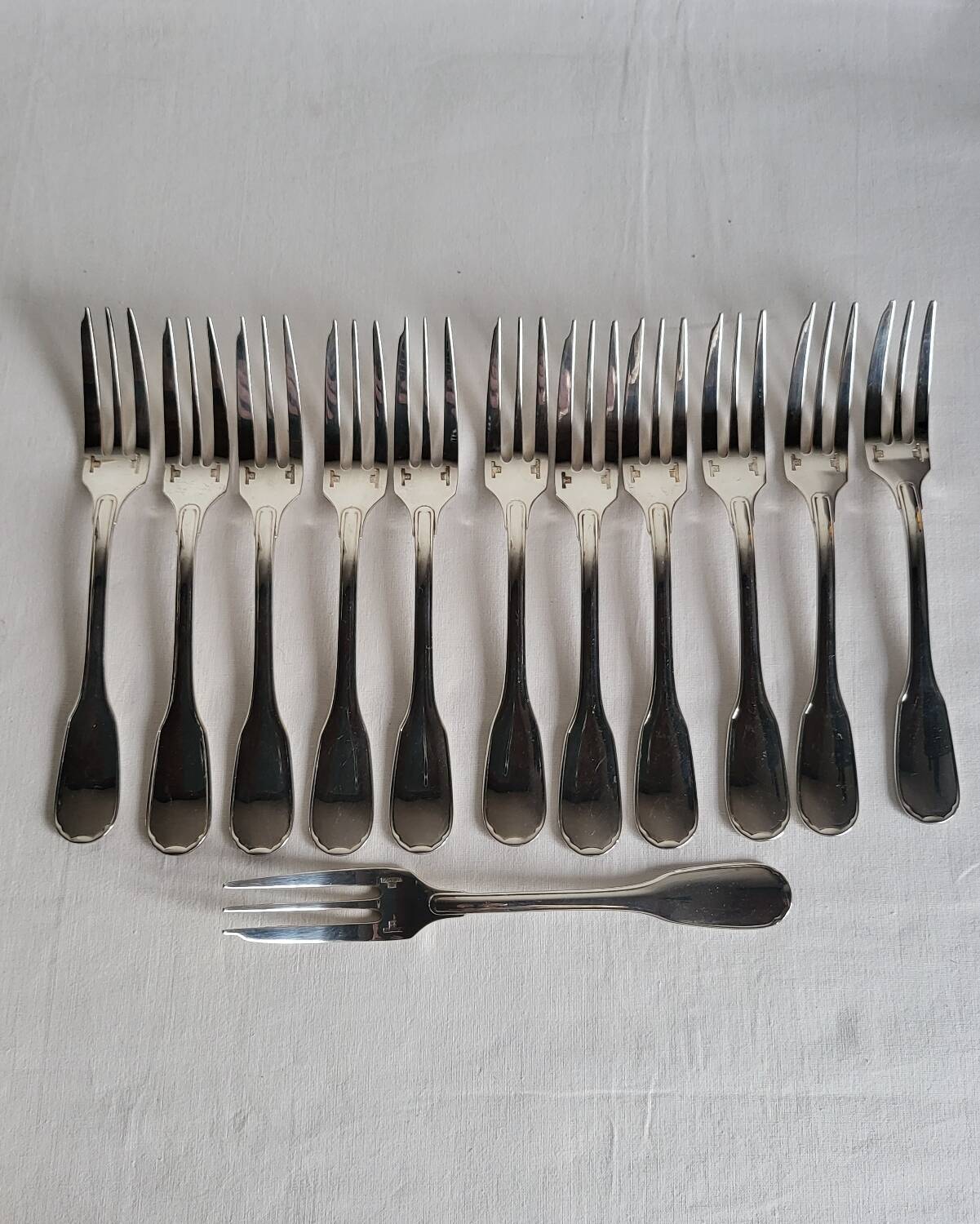 12 Christofle Versailles model cake forks in silver-plated metal.
