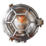Old cast aluminum wall light with hexagonal grid and wide streaked glass.