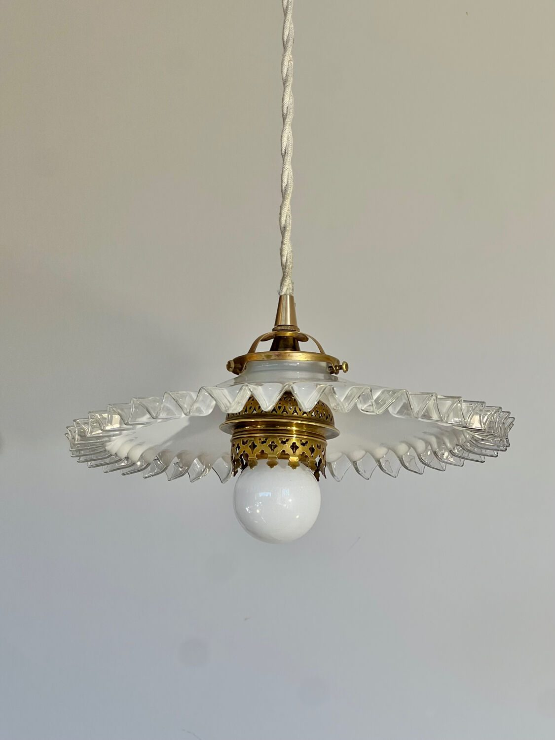 Opaline suspension in Art Deco style with a brass balcony featuring lace details.
