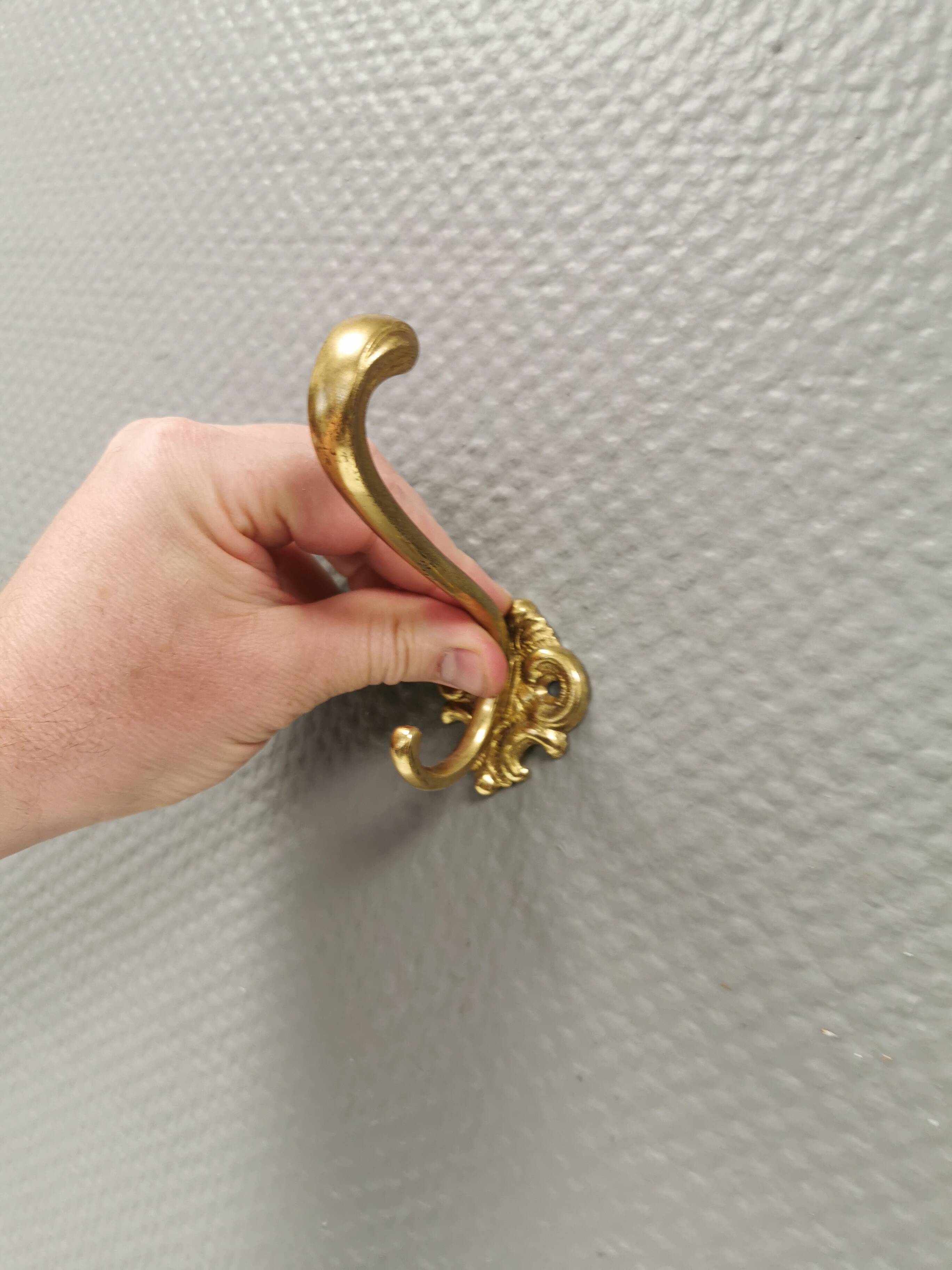 Three old and beautiful brass hooks with decorative motifs