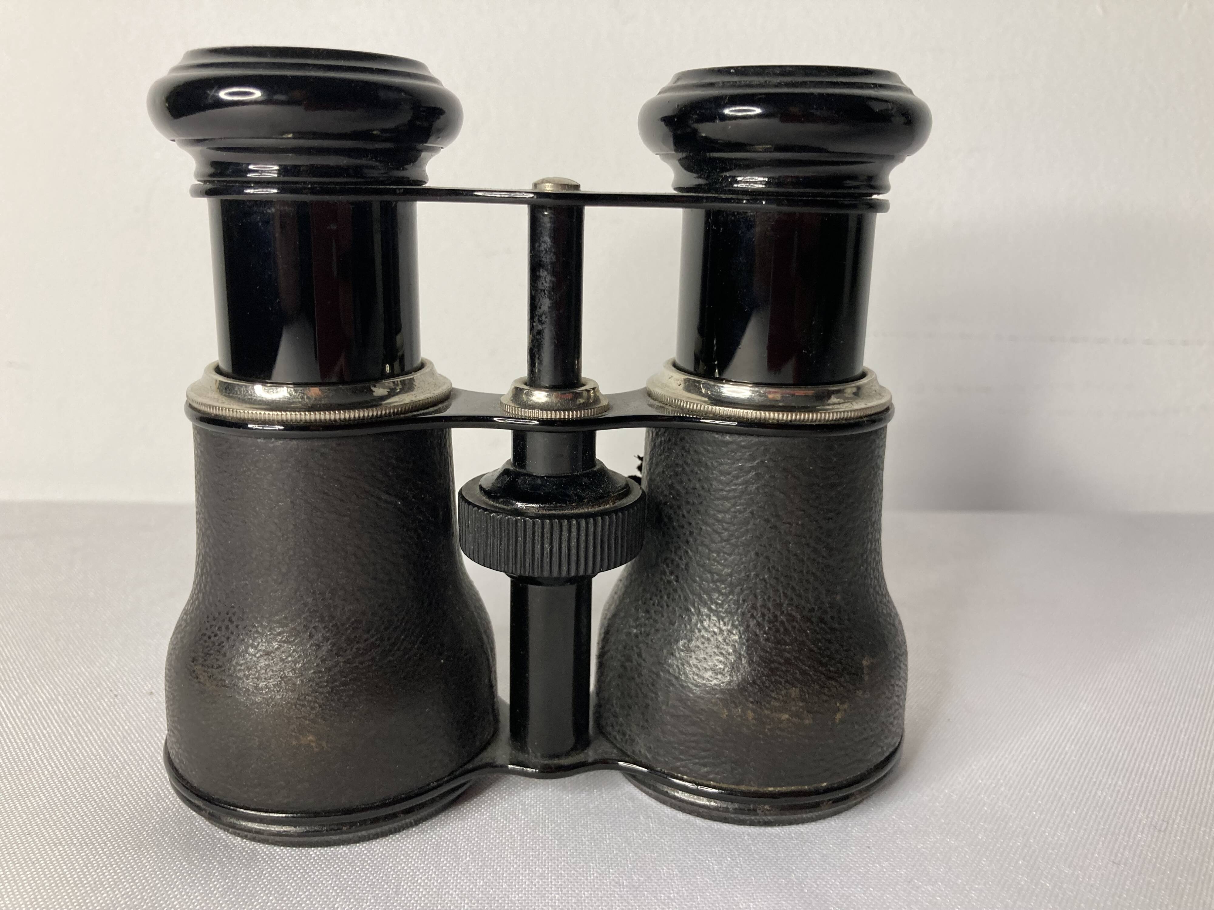 Old pair of binoculars sheathed leather black silver metal
