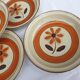 Set 11 plates 1970 Revernay Sarreguemines orange and brown on sandstone background