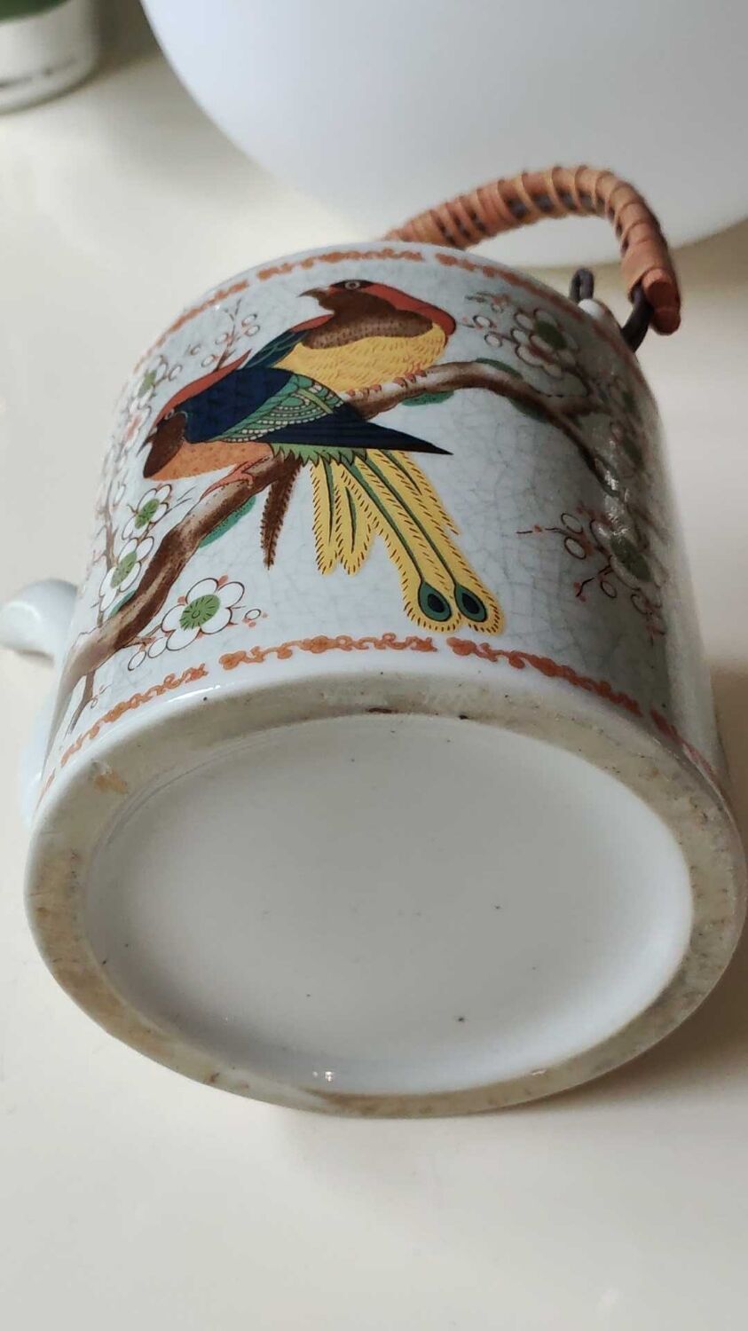 Japanese ceramic teapot. bird/paradise motifs/cherry trees. bamboo/rattan braided handle