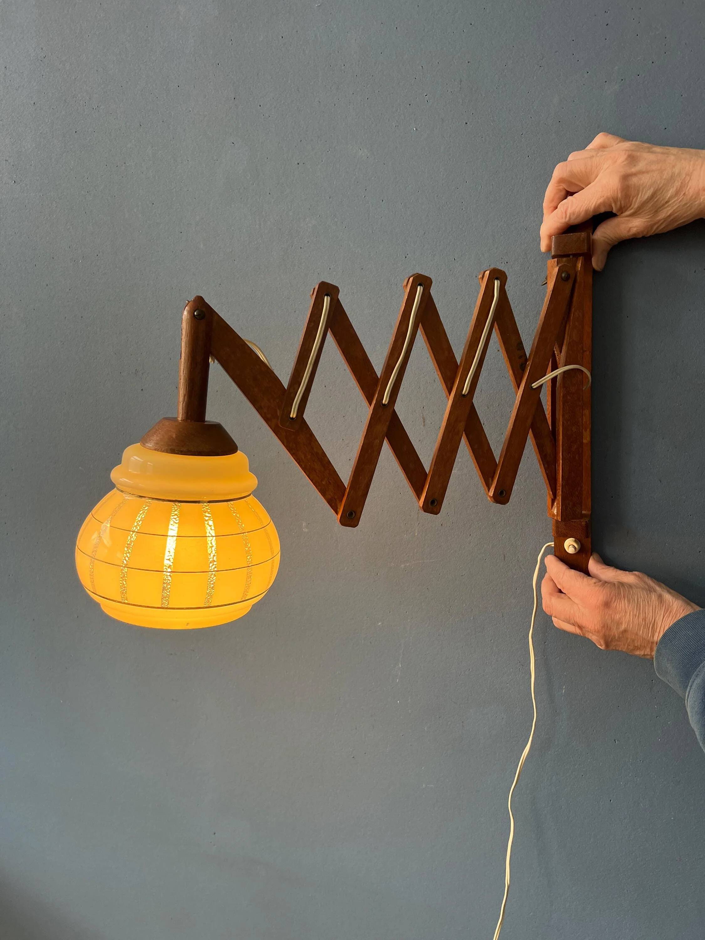 Vintage wall lamp with teak wood scissors and glass shade.