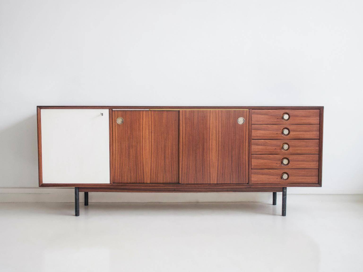 Wooden sideboard with sliding door and white drawers, around 1960.