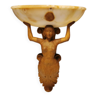 Wall lamp, where the base is a carved wooden lady holding the shade which is made of alabaster 1920s
