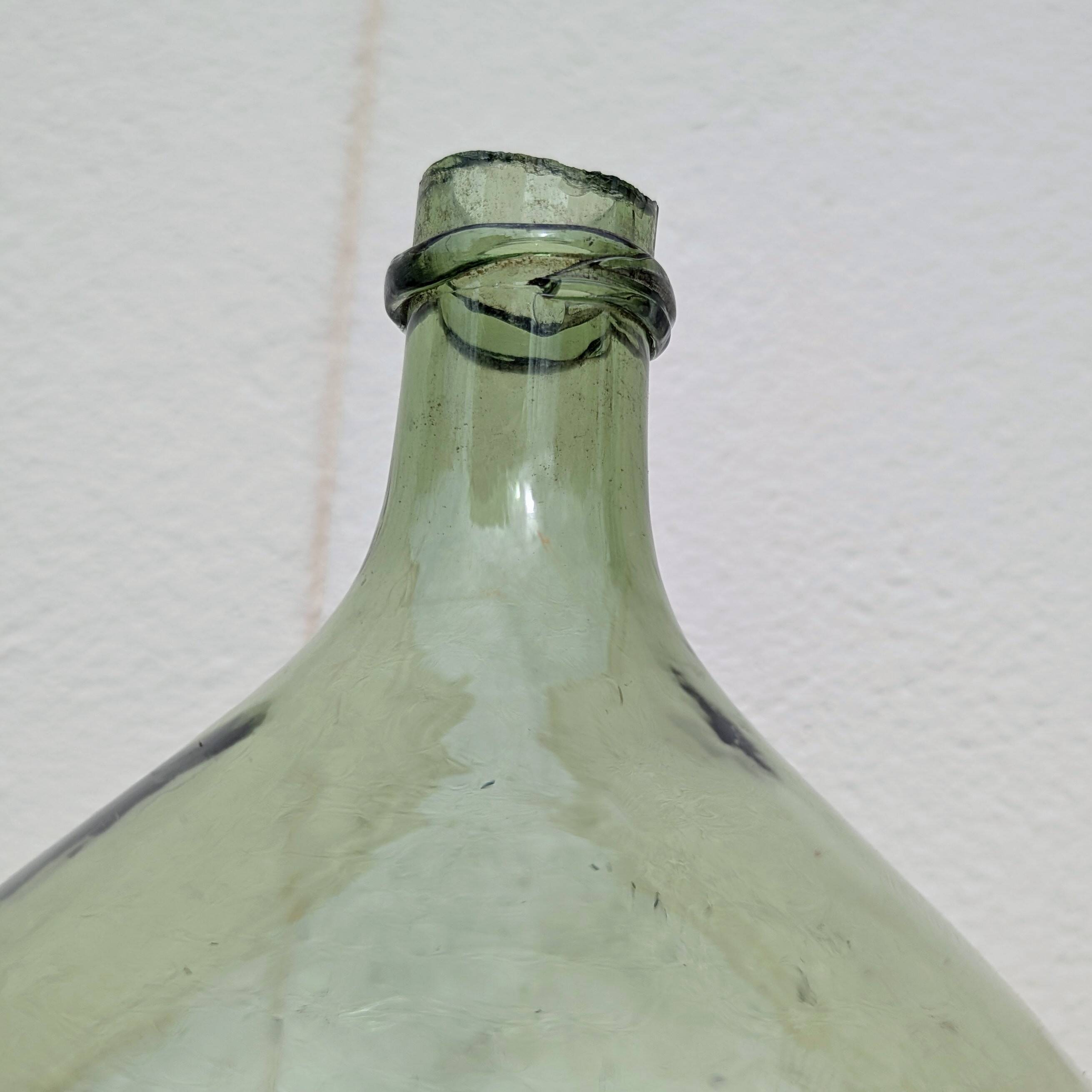 Give me a green glass jug made of blown glass.