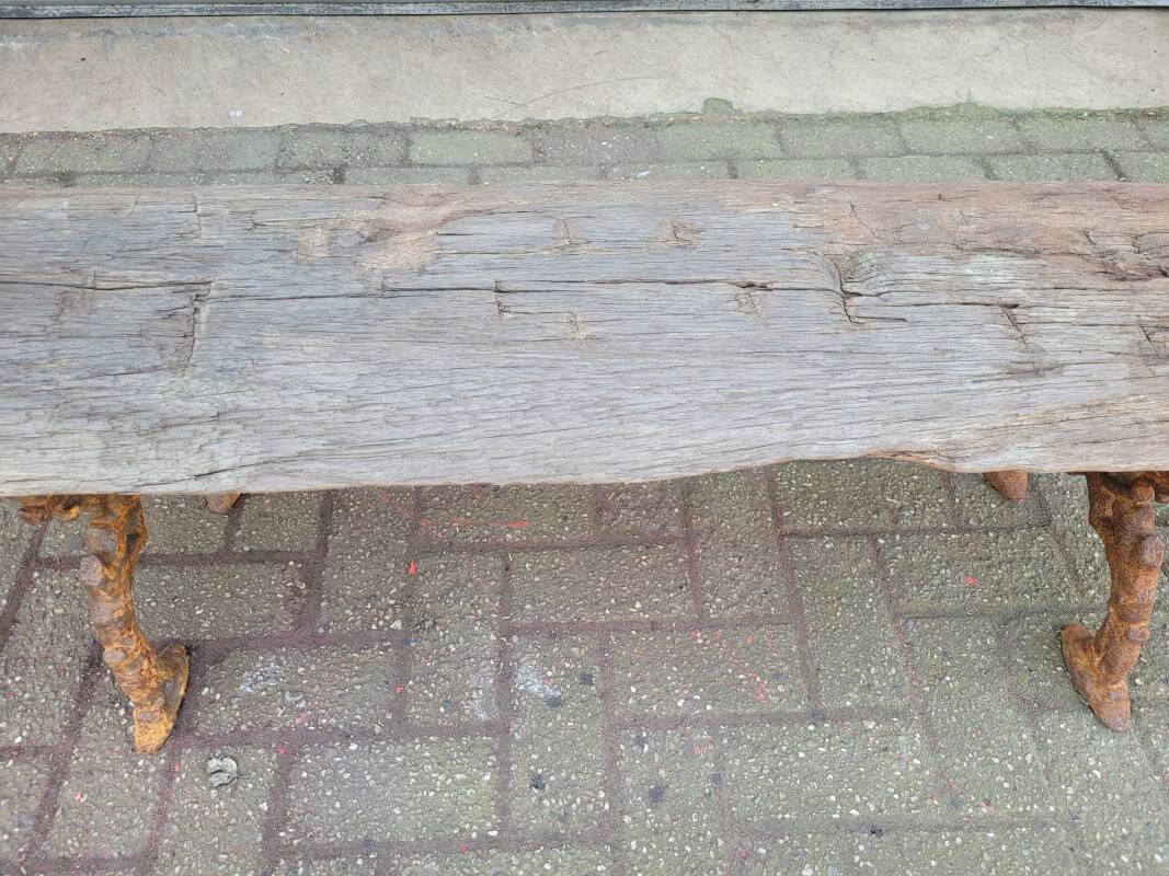 French country style cast iron bench with old rustic wooden plank