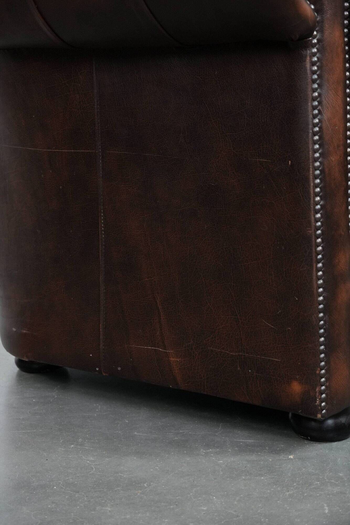 Brown Chesterfield armchair made of cowhide leather in English style