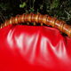 Fauteuil vintage rouge en rotin et skai rouge